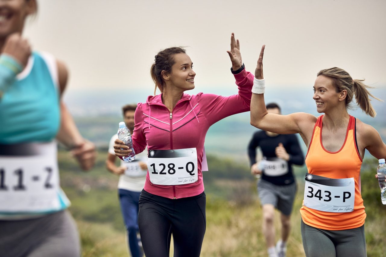 Inicio 14 happy-athletic-women-running-a-marathon-and-giving-high-five-to-each-other-.jpg